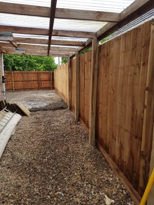 Tidy covered shingled area with a wooden fence