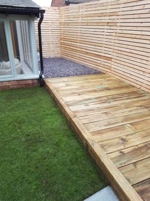 Small wooden decking area adjacent to lawn