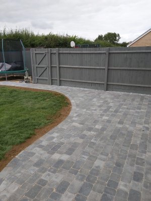 Patio with small grey tiles next to lawn