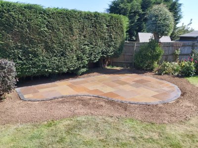 Curved sandstone patio with grey trim