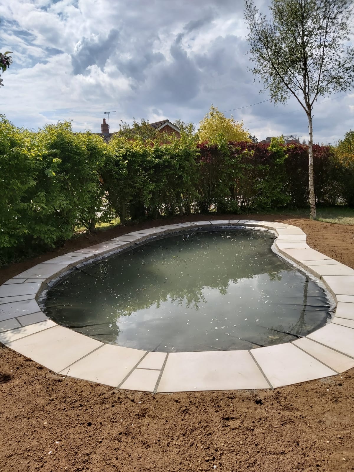 Beautiful garden pond with slabbed edging